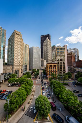 A bustling metropolitan avenue with towering structures on either side in Pittsburgh
