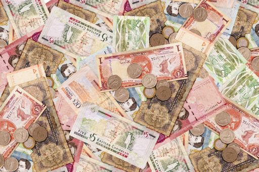 A high angle shot of many banknotes and coins laid on the ground - corruption concept