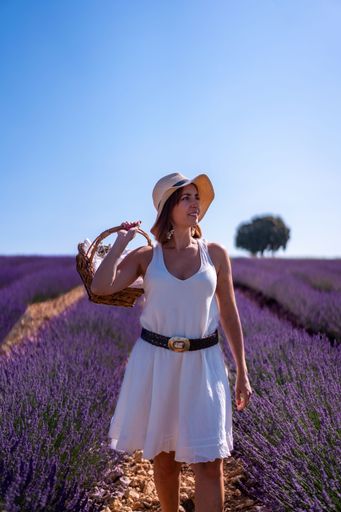 A vertical shot of a caucasian woman in a summer lavender field