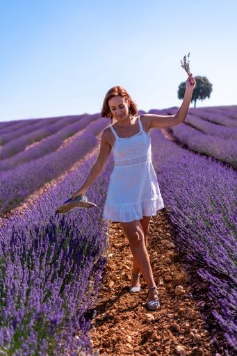 A vertical shot of a caucasian woman in a summer lavender field