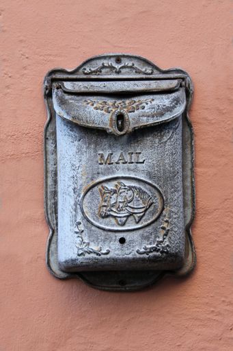 A vertical shot of an old mailbox on the wall