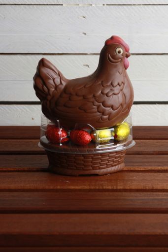 A vertical shot of a chocolate chicken and easter eggs