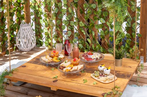 A closeup of a hanging wooden table with fresh desert in a wooden beach gazebo