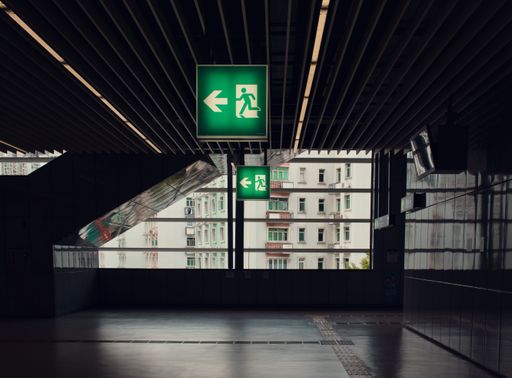 An exit signs illuminated with the green light in a train station