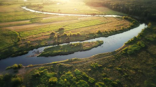 River Warta flowing through Poland at sunset in the evening, drone flight