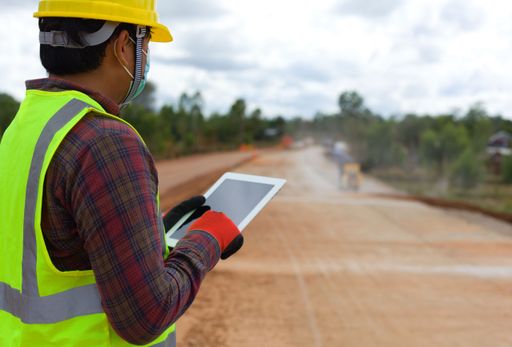 A worker managing the construction with a tablet