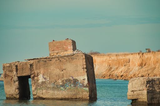 A small stone bomb shelter on shore of a tranquil sea