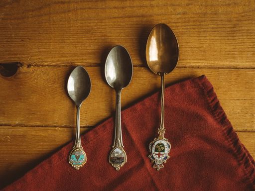 A top view of vintage silver spoons with coats of arms on a wooden background