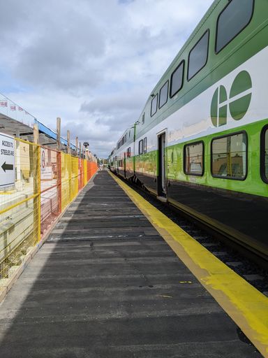 A vertical shot of a GO train passing by a station under construction in Toronto, Canada