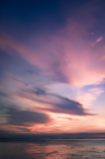 A breathtaking view of the sunset over a body of water. Great for phone backgrounds