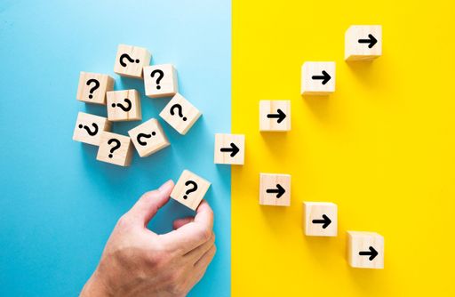 A hand choosing a block with a question mark for making the right decision