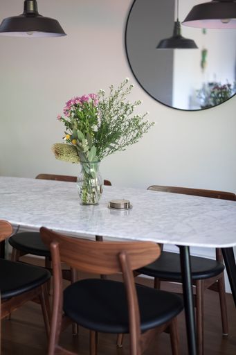 A vertical shot of a decorative vase with a floral bouquet on an empty dining table