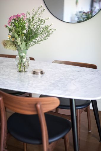 A vertical shot of a decorative vase with a floral bouquet on an empty dining table