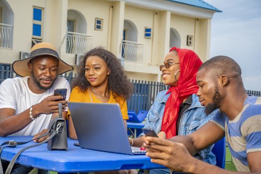 A group of young Africans sitting together around a table planning an online startup business