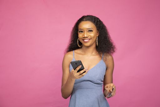 A young African female purchasing online using her smartphone and a credit card