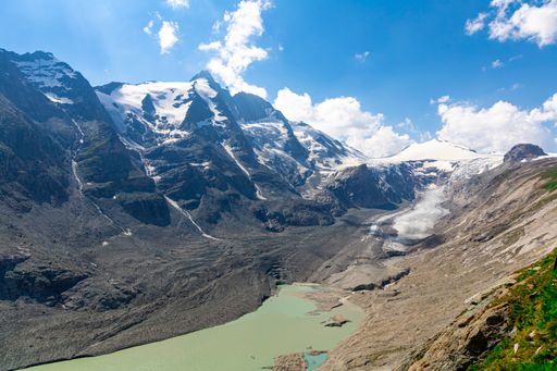 A high angle shot of a lake and snowy mountains on a cloudy day