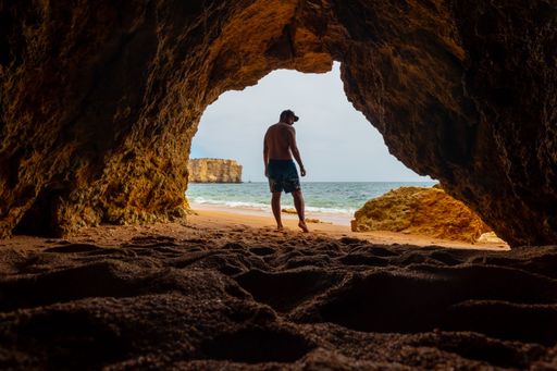 A Caucasian male in the natural cave on the beach at Praia da Coelha, Albufeira. Portugal
