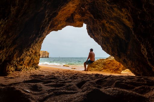 A Caucasian male in the natural cave on the beach at Praia da Coelha, Albufeira. Portugal