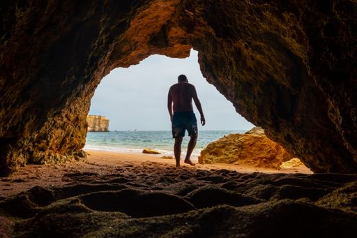 A Caucasian male in the natural cave on the beach at Praia da Coelha, Albufeira. Portugal