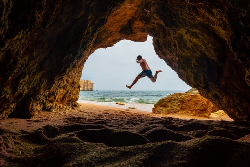 A Caucasian male in the natural cave on the beach at Praia da Coelha, Albufeira. Portugal