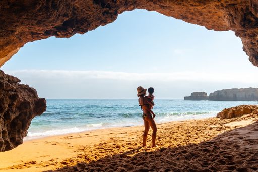 A Caucasian female with her son in the natural cave in the Algarve at Praia da Coelha, Albufeira