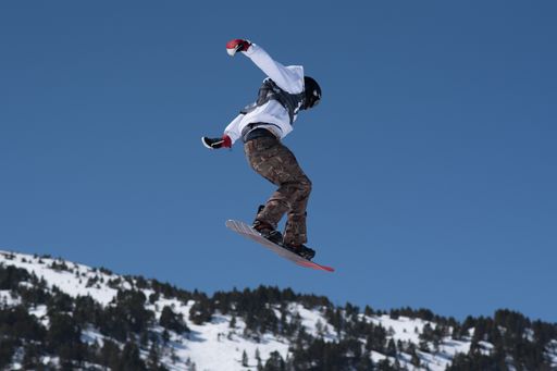 A low angle shot of a person snowboarding in Andorra