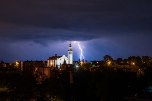 Bright lightning in the dark sky behind the church (Parish of the Martyrdom of St. John the Baptist in Laziska Gorne)