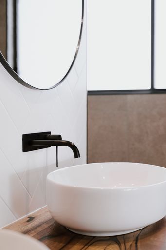 The beautiful modern style black faucet with ceramic sink in the bathroom