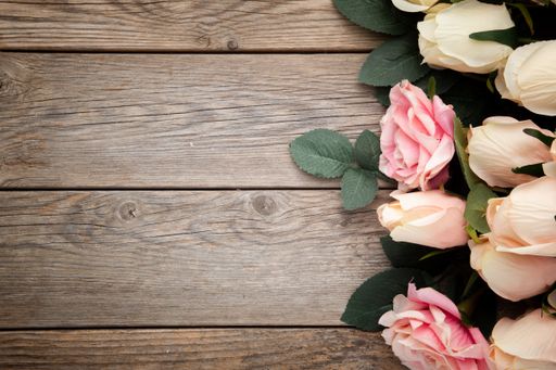 A top view of roses on a wooden surface with space for text