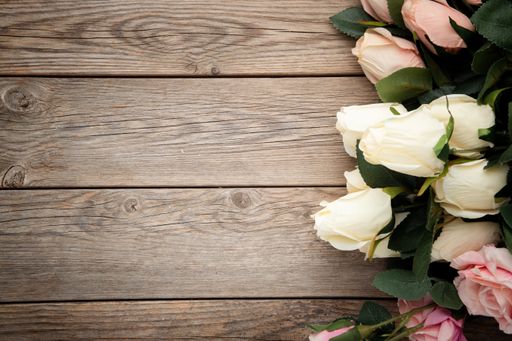 A top view of roses on a wooden surface with space for text