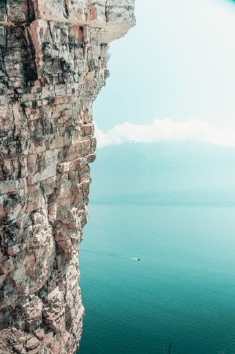 A beautiful shot of an ocean behind the huge cliff