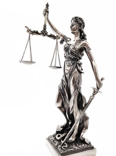 A vertical shot of the Lady Justice isolated on a white background