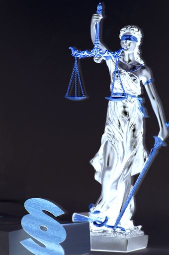 A vertical shot of Lady Justice with paragraph sign isolated on dark background