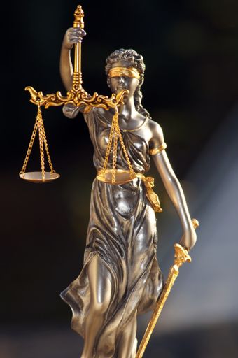 A vertical shot of Lady Justice  isolated on dark background