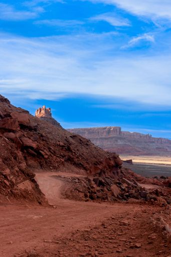 A vertical shot of a dirt road amid a canyon in Utah, USA, on a sunny day
