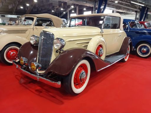 Berazategui, Argentina - Jul 22, 2022: Old vintage beige brown 1934 Chevrolet Chevy Master coupe cabriolet by GM on a red carpet. Classic car show