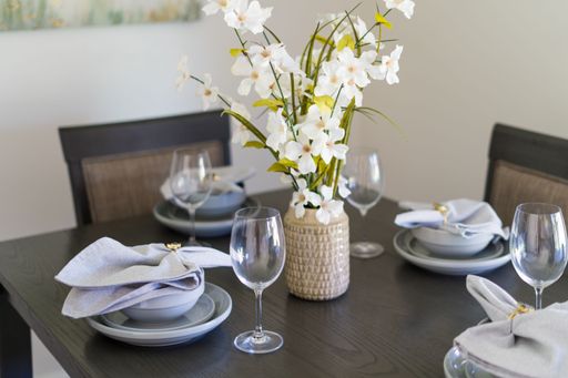 A table set in a restaurant with plates, napkins and wine glasses