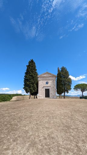 The small Chapel Vitaleta (Cappella della Madonna di Vitaleta) iin Italy under bright blue sky