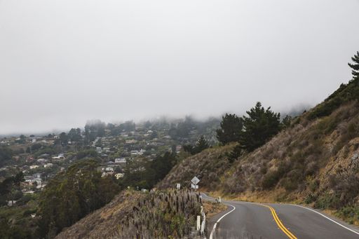 A beautiful high angle shot from a highway of a distant town covered in mist
