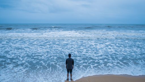 A shot of a young male on the beach looking to the seascape