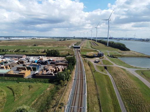A railway near wind turbines on a sunny day