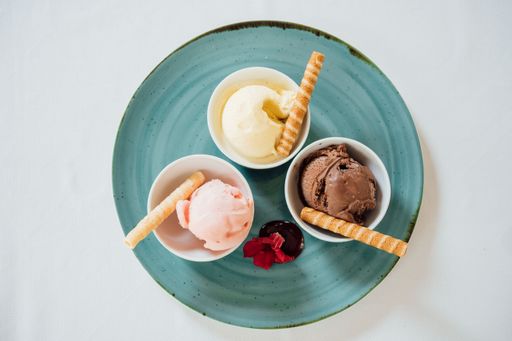 The top view of three ice creams in bowls served on the blue plate