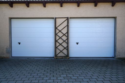 Two white closed garage doors on a being building
