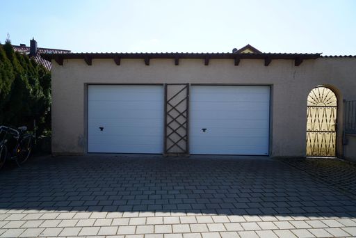 Two white closed garage doors on a being building