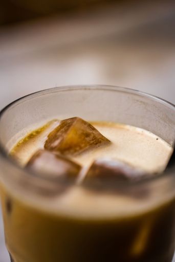 A vertical closeup of a glass of iced latte
