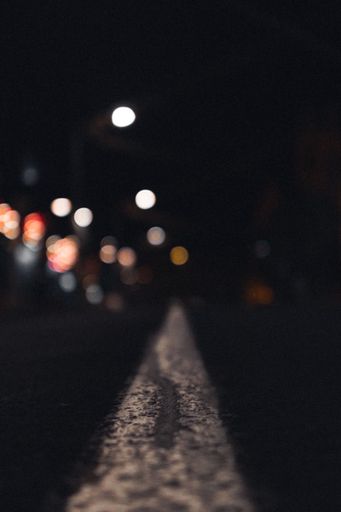 A straight line of road marking at night with blurry bokeh