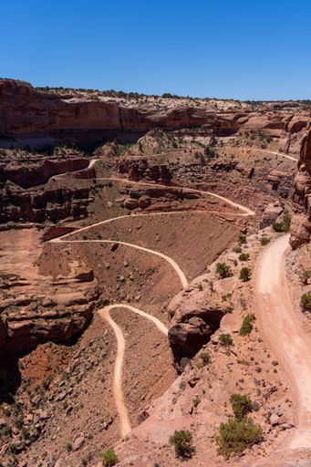 A vertical shot of the White Rim road through natural rocks in the Shafer Canyon in the US