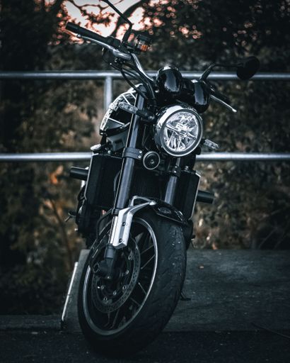 A vertical shot of a motorcycle parked on the edge of the road