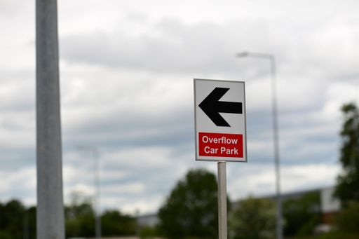 Directional sign against grey sky with selective focus