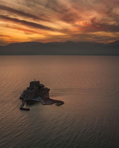 An aerial shot of the Bourtzi Castle in the middle of the Nafplio harbor in Peloponnese, Greece